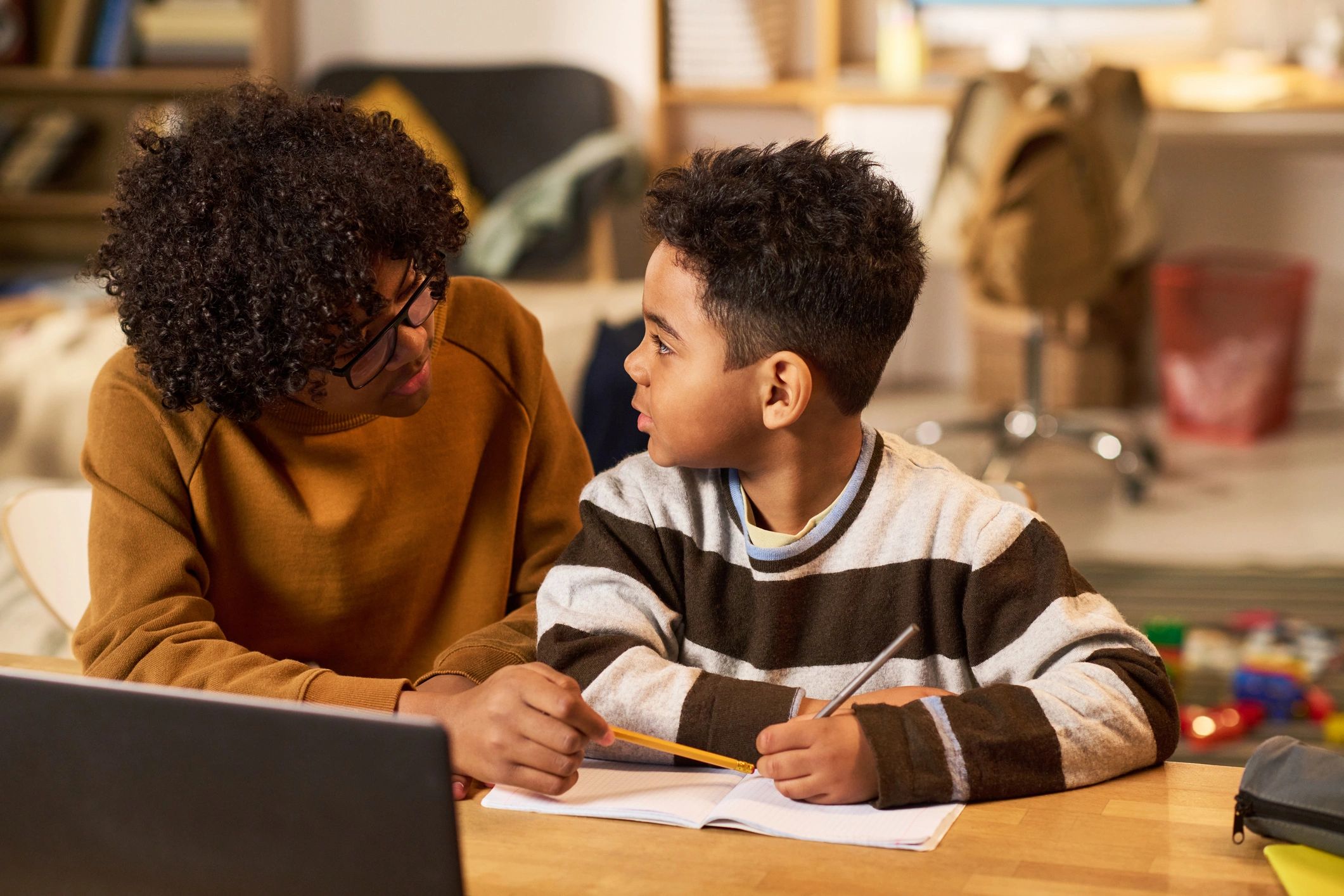 Teenager helping a younger student with homework